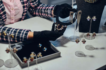 Close-up photo of a jewelry worker presenting a costly necklace with gemstones in a jewelry store.の写真素材