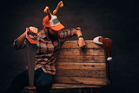 Carpenter wearing decorated christmas cap sitting on a wooden palette.の写真素材