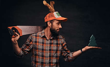 Christmas concept. Worker, carpenter, handyman is posing with a saw.の写真素材