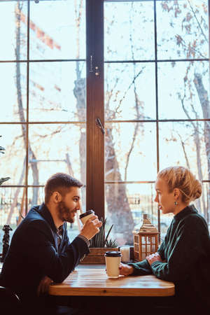Romantic couple in the cafe is drinking coffee and talking.の写真素材