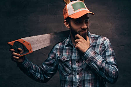 Christmas concept. Worker, carpenter, handyman is posing with a saw.の写真素材