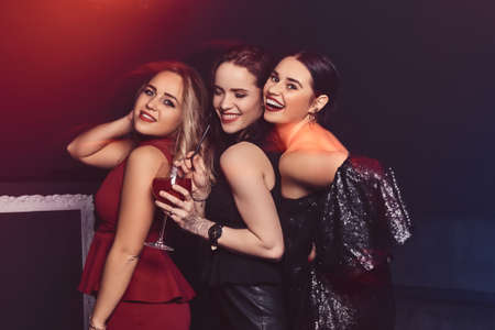 Beautiful elegantly dressed female friends have fun at the nightclubの写真素材