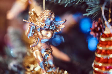 Golden angel playing the flute, a hanging ornament on a Christmas tree.の写真素材