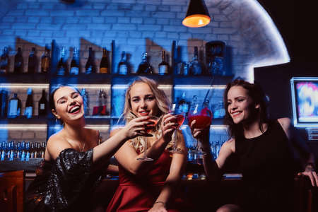 Portrait of cheerful friends toasting with cocktailsの写真素材