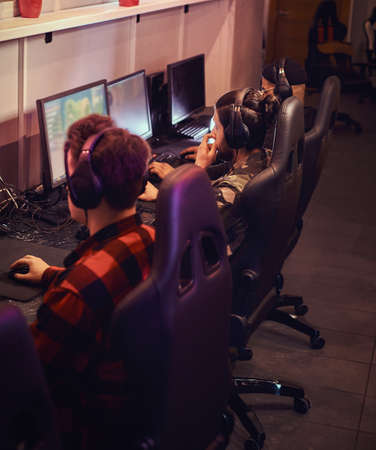 A team of professional cyber sportmans, trains for the championship, plays in a multiplayer video game on pc in a gaming club or internet cafe.の写真素材