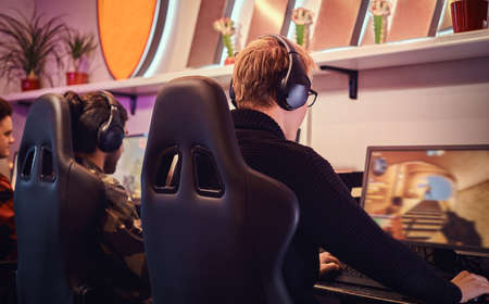 A team of professional cyber sportmans, trains for the championship, plays in a multiplayer video game on pc in a gaming club or internet cafe.の写真素材