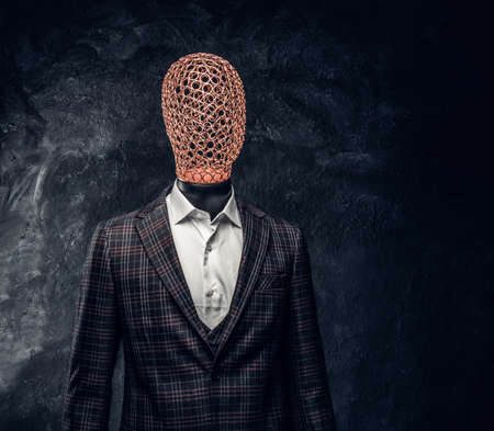 Male mannequin dressed in exclusive custom made men's suit in a dark tailor studioの写真素材