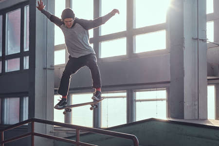 Skateboarder performing a trick on mini ramp at skate park indoor.