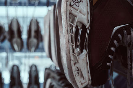 Equipment rental for ice skating. Rack with many pairs of skates inside.の写真素材