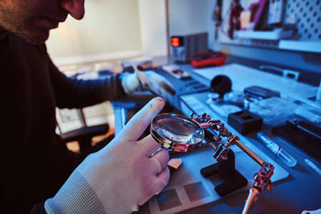 The technician repairs a broken tablet computer in a modern repair shopの写真素材