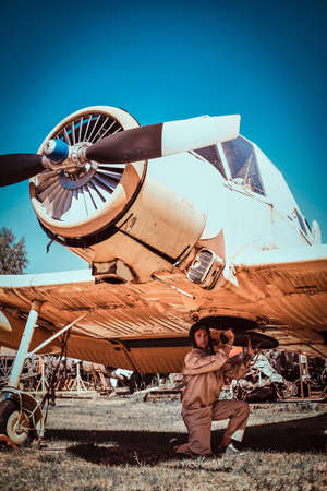 In nice and sunny summer day military pilot is repaing his own jet. Pilot is looking to the camera.の写真素材