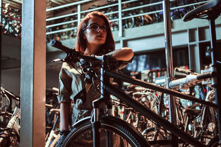 Hardworking attractive apperentice is chilling after fixing customers bicycle at workshop.