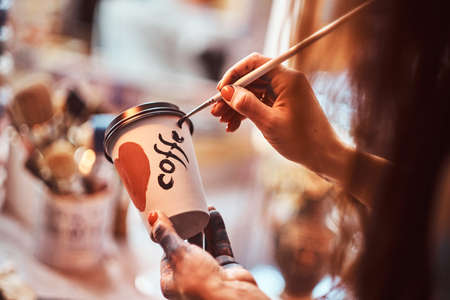 Process of creating a designer coffee cup for a customer. Art studio with necessary tools at...