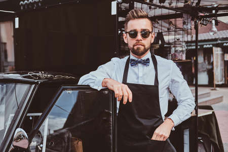Smart trendy barista in glasses has a break at his own coffee shop.の写真素材