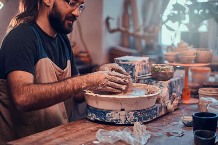 Pensive man is working on his big new clay project.