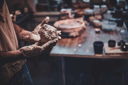 Closeup photoshoot of working process with clay by diligent man.の写真素材