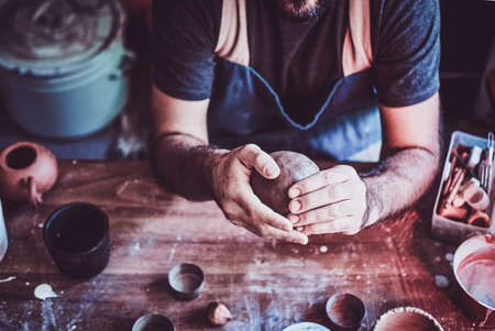Closeup photoshoot of working process with clay by diligent man.の写真素材