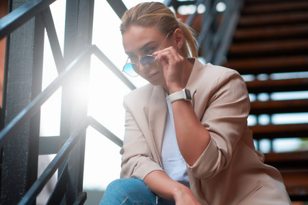 Portrait of beautiful casual attractive woman on steel stairs at back yard.
