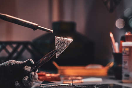 Process of working with iron solder, making new part of lamp. Closeup photo shoot.の写真素材
