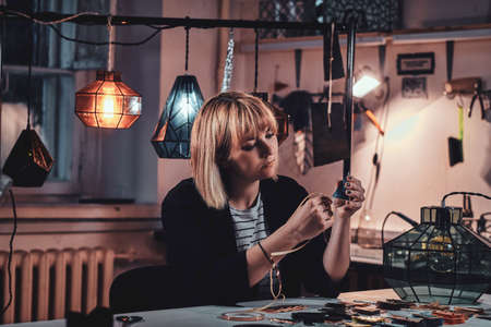 Talanted woman is working on her new lamp project at artisan lamp studio.