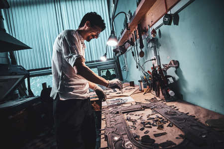 Diligent craftman is restoring ancient broken stained glass at his own workshop.の写真素材