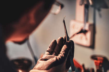 Craftsman at his restouration workshop with plies and peace of stained glass in his hands.の写真素材