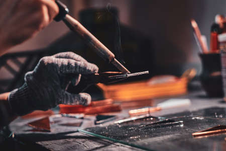 Closeup photo shoot of of soldering using pliers and peace of glass.の写真素材