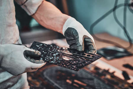 Restorer is choosing right peace of stained glass for his beautiful vintage project.の写真素材