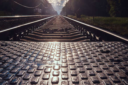 Low angle photo of rails and sleepers and pedastrin transition in sunshining summer day.の写真素材