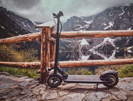 Touristic view point with amaizing view of mountains and lake with mirroed reflection. Trere are scooter at the front.の写真素材