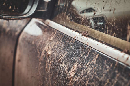 Closeup photo shoot of dirty cars mirror, door and window, splash and texture of mud on silver car.の写真素材