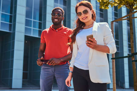 Good friends in sunglasses are meeteng up at bright summer day at city centre.の写真素材