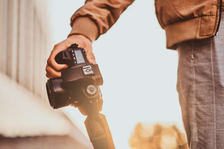Man in casual outlook is holding his digital photo camera in hand while visiting interesting places.の写真素材