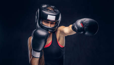 Brave woman is ready to fight, she is wearing boxer gloves and protective helmet.の写真素材