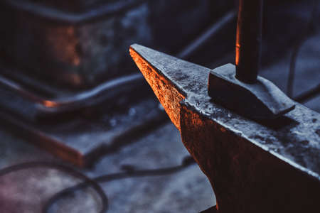 Close up photo shoot of hammer and anvil at dark smith workshop.の写真素材