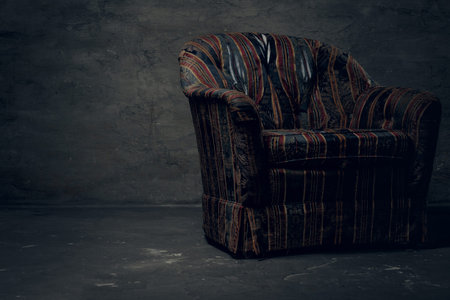 Old armchair in an empty dark studio