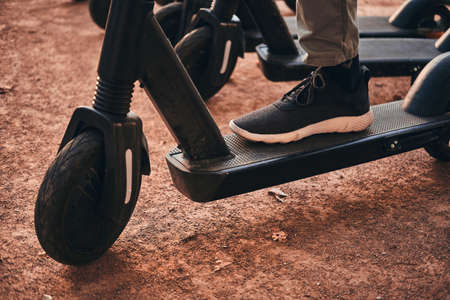 Closeup photo shoot of mans foot in sportive shoes on the scooter.の写真素材
