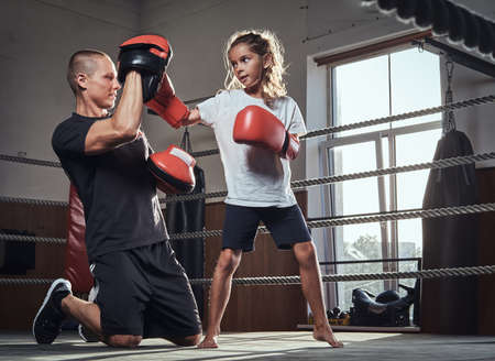 Young boxer trainer is training new girl boxer for special competitions.の写真素材