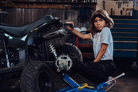 Serious beautiful girl want to be an auto technician when she grows up, she is trying to fix broken...