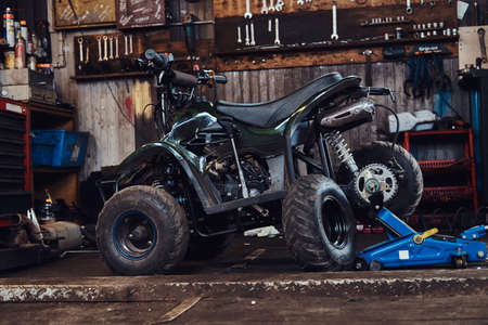 ATV with broken wheel at auto service workshop is waiting to be fixed.の写真素材