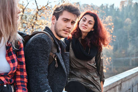 Best friends are posing for photographer while walking in autumn forest.の写真素材