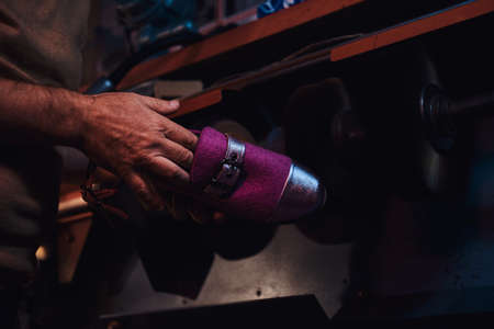 Experienced pensive person is making custom made shoes at his personal workshop.の写真素材