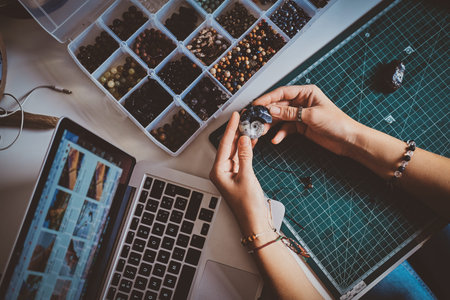 Talanted girl with interesting hobby is creating necklace using shell at her workshop.