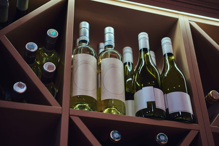 Bottles of tasty wine in posh reastoraunt are stored on the shelf.