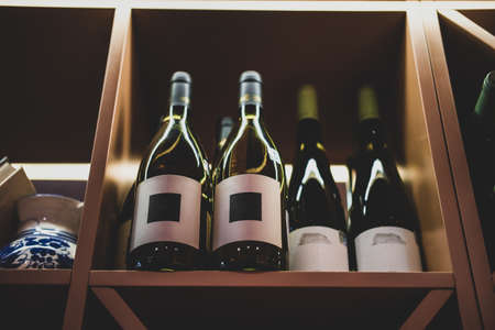 Bottles of tasty wine in posh reastoraunt are stored on the shelf.