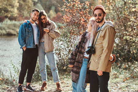 Beautiful romantic couples of young people are enjoying their walk in the autumn park.の写真素材