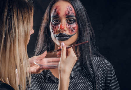 Talented makeup artist is creating special scary Halloween art on womans face.の写真素材