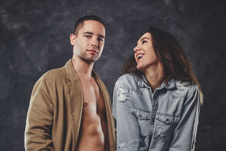 Pensive man is posing for photographer with his smiling girlfriend at photo studio.の写真素材
