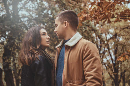 Beautiful couple is enjoying day walk at autumn parkの写真素材
