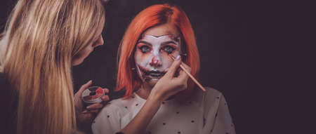 Talented makeup artist is creating special scary Halloween art on womans face.
